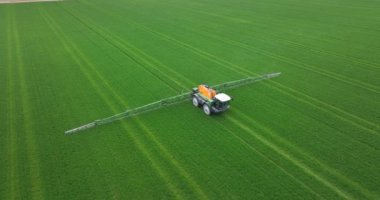 Creil, Hollanda, 15 Nisan, 2023. Hollanda 'da ilkbaharda tarlalarda çalışan bir tarım çiftçisi ile araziyi ilaçlayan bir traktörün hava aracı görüntüsü..