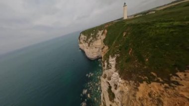 FPV dağ sörfünün hava aracı görüntüsü, Normandiya kayalıkları. Uçuyor tepeler ve sarp kayalıklar boyunca.