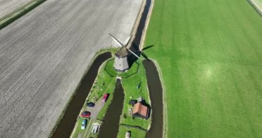 Hollandalı polen manzarasında geleneksel yel değirmeni. Hollanda kültürü ve mirası. Tarihten mühendislik. Su pompalıyorum. Hava aracı görünümü.