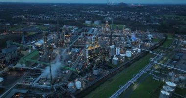 Gelschenkirchen, Almanya 'da fosil yakıt rafinerisi. Hava aracı görüntüsü. Büyük depolama tankları ve boru hattı. Büyük endüstriyel tesis. Karanlık ve gece görünümü.