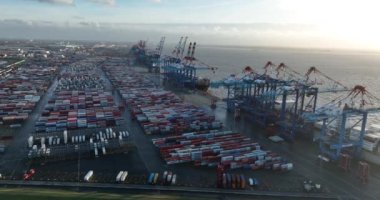 Bremerhaven, Almanya, 29 Aralık 2023: Bremerhaven 'daki konteyner terminali. Konteynır yükleme ve boşaltma ve büyük ölçekli vinçler. İskeledeki depo ve konteynırlar. Kuşlar