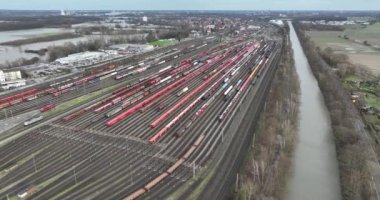 Demiryolu taşımacılığı. Büyük bir depo tren istasyonu. Trenler ve arabalar. Almanya 'da kuş bakışı drone görüntüsü.