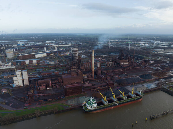 Bremen, Free Hanseatic City of Bremen, Germany, December 29th, 2023: ArcelorMittal Bremen a steelworks on the banks of the River Weser in Bremen, Germany. Aerial drone view.