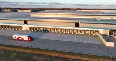 Almere, Flevoland, Hollanda, 7 Ocak 2024: Lidl dağıtım merkezi, SDV kamyon lojistik şirketi faaliyette. Gün batımında kuş gözü drone görüntüsü. Yol üzerinde ürün dağıtımı.