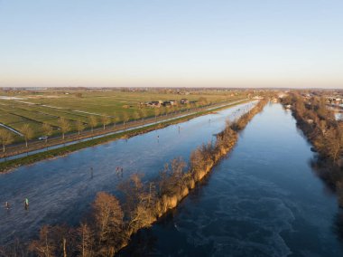Hollanda 'daki kanallarda buz pateni. Kış gün batımı ve buzdaki insanlar. Hava aracı kuş bakışı.