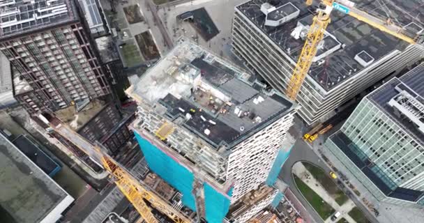 オランダ ユトレヒト 2024年2月7日 高層ビルと背景にあるユトレヒト市の中心部のスカイラインの建設現場 作動中のクレーンや建設作業員 エアリアル — ストック動画