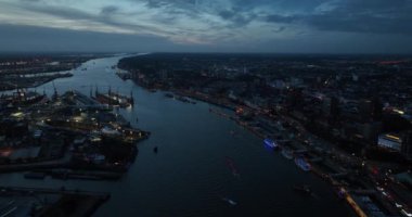 Hamburg 'daki Elbe Nehri ve geceleri nehir boyunca uzanan şehir merkezi. Bir tarafta Hamburg limanını, diğer tarafta da St Pauli şehir merkezini görüyoruz. Hava aracı görünümü.