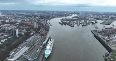 Hamburg, Kreisfreie Stadt, Almanya, 30 Aralık 2023: Hamburg Cruise Center Altona 'da hava aracı görüntüsü, yolcu gemisi onun yanına yanaştı. Elbe Nehri ve arka plandaki şehir. Bulutlu bir gün.