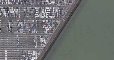 Bir RoRo terminalinin havadan aşağı görüntüsü. Terminalde yuvarlanmanın kısaltılmışı. Belçika, Zeebrugge limanında seyir halindeki araçların nakliyesi.