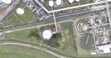 Kuşlar kimya endüstrisine tepeden bakan drone görüntüsü, depolama konteynırları, duman, borular, hatlar, tanklar, reyetoirler, duman yığınları, ağır sanayi faaliyette. Tesis ve kurulum.