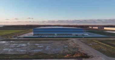 Hollanda 'da bir süpermarket zinciri için modern yeni üretim dağıtım merkezi. Nakliye aracı kamyonlarla yol üzerinde. Tüketici ürünlerinin depolanması ve dağıtımı. Hava aracı görünümü.