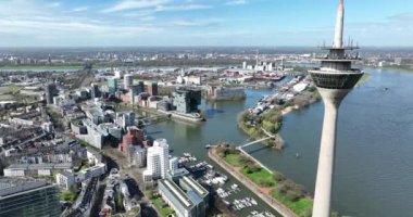 Bir zamanlar eski liman olan Düsseldorf 'un Medienhafen' i şimdi modern mimari, restoranlar ve eğlence merkezleriyle yenilendi. Rheinturm ve Rhein nehrinin yanında, Dusseldorf, Kuzey Ren