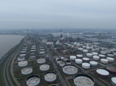 Antwerp limanındaki rafineride hava aracı görüntüsü. Fosil yakıtların işlenmesi. Gün batımında petrol endüstrisi. Ağır endüstriyel tesis. Silo konteynırları ve bacalar. Antwerp, Belçika.