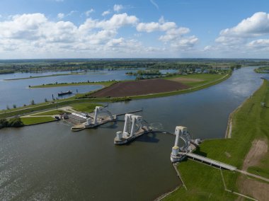 The Maurik hydroelectric power station and generating electricity from flowing water. Aerial drone view on energy infrastructure. The Netherlands. clipart