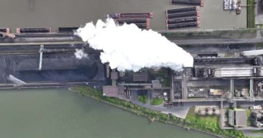 Aerial top-down view of smoke and vapor coming out of a cooling tower at a cokes factory. Duisburg, Germany.