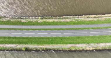 Driving road along the water in The Netherlands. Transportation by automobile. Birds eye view.