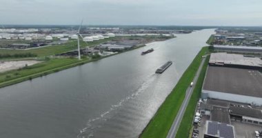 Aerial drone view of the port of Amsterdam and ships sailing through the Noordzeekanaal, the canal leading to the North Sea, emphasizing industrial transportation over water in the Netherlands.