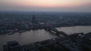 Cologne, Germany, aerial hyperlapse, time lapse of the cathedral and railways bridge. Downtown city center along the rhine river at sunset.