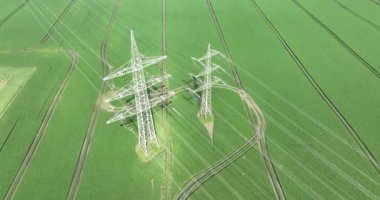 High voltage pylons masts in the high-voltage grid the transport of large amounts of electrical energy over large distances. Aerial drone view.