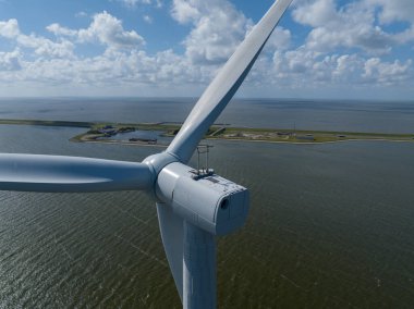 Suyun üzerinde rüzgar türbinleri. İklim değişikliği çözümü, rüzgarın sürdürülebilir yeşil enerjisi.