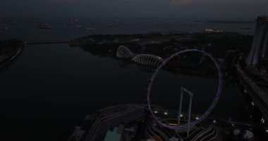 Singapur, Marina Körfezi Merkez Bölgesi, Singapur, 4 Temmuz 2024: SIngapur Körfezi kıyısındaki Bahçe, Çiçek Kubbesi, Bulut Ormanı, OCBC Skyway ve Singapur Flyer gece vakti, Marina Körfezi. Hava görünümü.