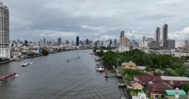 Bangkok şehri manzarası, menam nehri, Tayland 'da binalar ve tekneler. Gündüz bulutlu bir gün. Hava aracı videosu.
