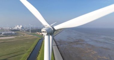 Hollanda, Eemshaven 'daki bir rüzgar değirmeninin insansız hava aracı videosu. Sürdürülebilir yeşil enerji üretimi. Enerji geçişi. Hava görünümü.