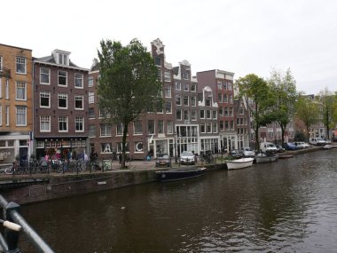 Amsterdam, Kuzey Hollanda, Hollanda, 2 Ekim 2024: Amsterdam şehir merkezindeki kanal evleri, ikonik tarihi Hollanda mimarisi, sokak manzarası. Geleneksel evler.