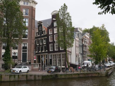 Amsterdam, Kuzey Hollanda, Hollanda, 2 Ekim 2024: Amsterdam şehir merkezindeki kanal evleri, ikonik tarihi Hollanda mimarisi, sokak manzarası. Geleneksel evler.