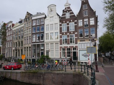 Amsterdam, Kuzey Hollanda, Hollanda, 2 Ekim 2024: Amsterdam şehir merkezindeki kanal evleri, ikonik tarihi Hollanda mimarisi, sokak manzarası. Geleneksel evler.