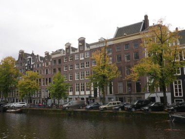 Amsterdam, Kuzey Hollanda, Hollanda, 2 Ekim 2024: Amsterdam şehir merkezindeki kanal evleri, ikonik tarihi Hollanda mimarisi, sokak manzarası. Geleneksel evler.