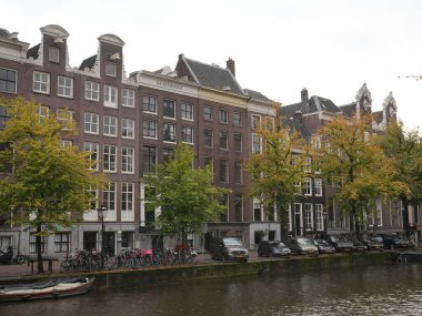 Amsterdam, Kuzey Hollanda, Hollanda, 2 Ekim 2024: Amsterdam şehir merkezindeki kanal evleri, ikonik tarihi Hollanda mimarisi, sokak manzarası. Geleneksel evler.