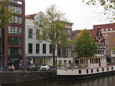 Amsterdam, Kuzey Hollanda, Hollanda, 2 Ekim 2024: Amsterdam şehir merkezindeki kanal evleri, ikonik tarihi Hollanda mimarisi, sokak manzarası. Geleneksel evler.