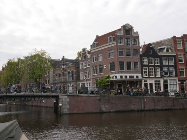 Amsterdam, Kuzey Hollanda, Hollanda, 2 Ekim 2024: Amsterdam şehir merkezindeki kanal evleri, ikonik tarihi Hollanda mimarisi, sokak manzarası. Geleneksel evler.