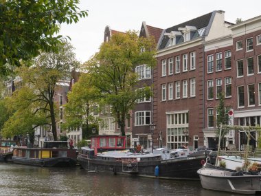 Amsterdam, Kuzey Hollanda, Hollanda, 2 Ekim 2024: Amsterdam şehir merkezindeki kanal evleri, ikonik tarihi Hollanda mimarisi, sokak manzarası. Geleneksel evler.