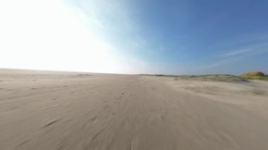 Wadden Adası, Textel ve FPV 'nin alacakaranlıklarında dinamik bir uçuş. Hollanda 'da sahil, kum tepeleri, kum. Turistik bir yer. Hava görünümü.