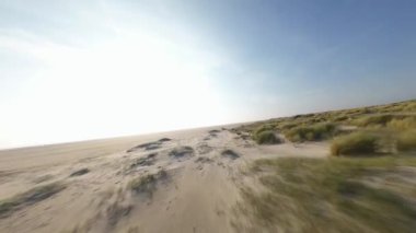 FPV İHA 'sı Texel, Hollanda' nın kumullarında dinamik drone videosu çekiyor. Doğa, kara, kum ve deniz..