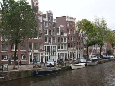 Amsterdam, Kuzey Hollanda, Hollanda, 2 Ekim 2024: Amsterdam şehir merkezindeki kanal evleri, ikonik tarihi Hollanda mimarisi, sokak manzarası. Geleneksel evler.