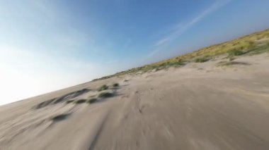 FPV İHA 'sı Texel, Hollanda' nın kumullarında dinamik drone videosu çekiyor. Doğa, kara, kum ve deniz..