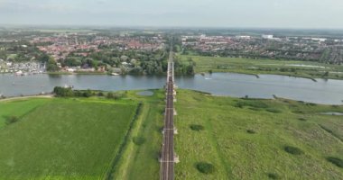 Hollanda Culemborg, Gelderland 'daki Lek nehri üzerindeki demiryolu köprüsünün insansız hava aracı videosu..
