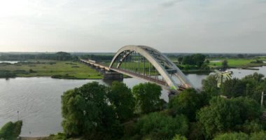 Culemborg, Gelderland, Hollanda, 6 Ağustos 2024 Culemborg, Hollanda 'daki köprüden geçen NS sprinter. Toplu taşıma treni. Hava aracı videosu.