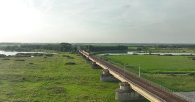 Culemborg, Gelderland, Hollanda, 6 Ağustos 2024 Culemborg, Hollanda 'daki köprüden geçen NS şehirlerarası. Toplu taşıma treni. Hava aracı videosu.