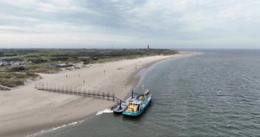 Gemide hava aracı görüntüsü var. Texel 'deki deniz komandolarını izlemek için. Arka planda Texel deniz feneri.