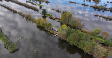 Loosdrechtse Plassen, Scheendijk, Breukelen, Hollanda marinasında küçük evler, çekici delikleri ve legakkerleri olan doğa rezervi. Sonbaharda hava aracı videosu.