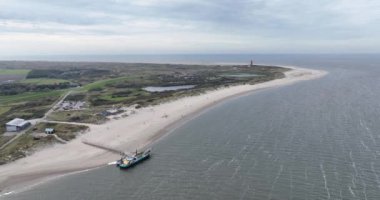 Gemide hava aracı görüntüsü var. Texel 'deki deniz komandolarını izlemek için. Arka planda Texel deniz feneri.