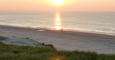 Gün batımında sahilde yürüyen çift, ilişkiler, çiftler, aşk. Hava görünümü.