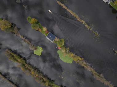 Bir hava aracı Loosdrechtse Plassen 'deki su üzerindeki küçük evleri, su doğasındaki boş evleri görüyor..