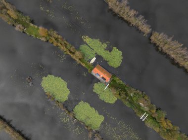 Bir hava aracı Loosdrechtse Plassen 'deki su üzerindeki küçük evleri, su doğasındaki boş evleri görüyor..