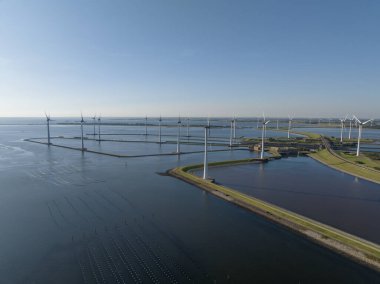 An aerial photo of wind turbines at Krammersluizen, water way sluices and locks infrastructure aerial drone view. clipart