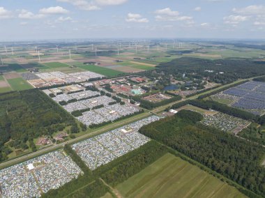 An aerial drone photo of large music festival including campground in Biddinghuizen, The Netherlands. clipart